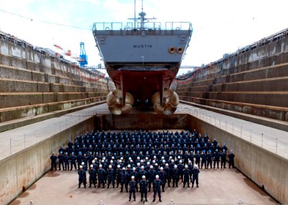 US Navy 100527-N-2218S-002 The officers and crew of the Arleigh Burke-class guided-missile destroyer USS Mustin (DDG 89) pose for a group photo under the ship's screws at Fleet Activities Yokosuka