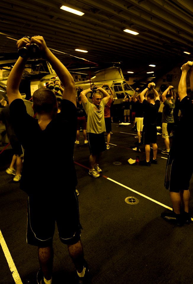 US Navy 100527-N-7948R-073 ailors and Marines work out in the hangar bay aboard the amphibious assault ship USS Peleliu (LHA 5)