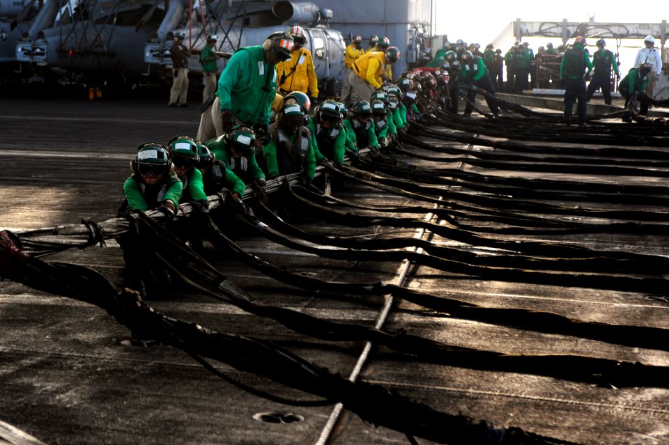 US Navy 100527-N-6604E-230 Sailors aboard the aircraft carrier USS Dwight D. Eisenhower (CVN 69) practice setting up an emergency aircraft landing barricade during a drill