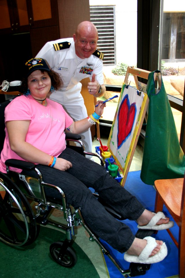 US Navy 100525-N-6220J-145 Lt. Glenn Sircy, assigned to the Navy Office of Community Outreach, gives a thumbs up on a painting by a patient from the Arkansas Children's Hospital during a Caps For Kid's event