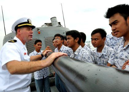 US Navy 100527-N-7643B-114 Lt. j.g. David Kellen explains the capabilities of the 76mm (3-inch)-62 caliber MK 75 rapid-fire gun to a group of Indonesian high school students aboard the guided-missile frigate USS Vandegrift (FFG