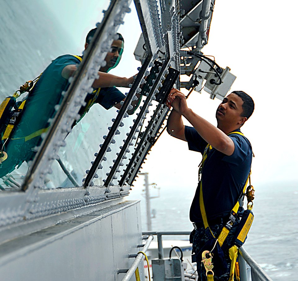 US Navy 100526-N-6003P-081 Quartermaster 2nd Class Antonio Huber cleans the flag bridge windows aboard the Nimitz-class aircraft carrier USS Harry S. Truman (CVN 75)