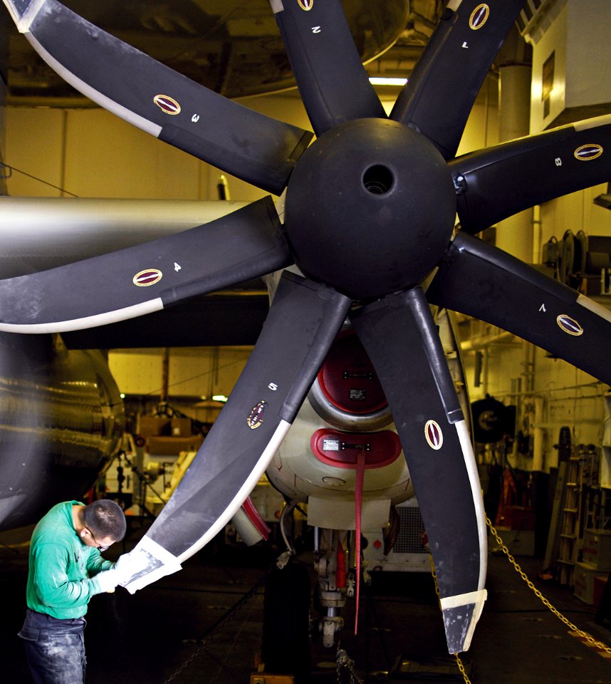 US Navy 100525-N-7317W-002 Aviation Structural Mechanic Airman John Irving sands the propeller tip of an E-2C Hawkeye assigned to the Seahawks of Airborne Early Warning Squadron (VAW) 126