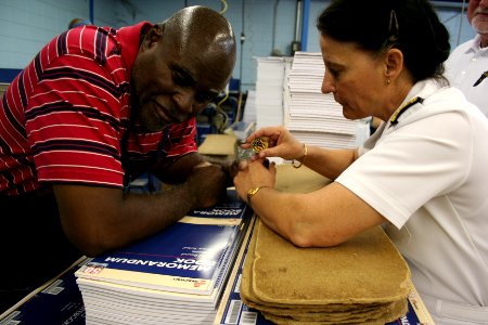 US Navy 100526-N-6220J-150 Rear Adm. Wendi B. Carpenter, Commander, Navy Warfare Development Command, Norfolk, presents her command coin to Earl McClure, a punchpress operator with 35 years service at the Arkansas Lighthouse fo