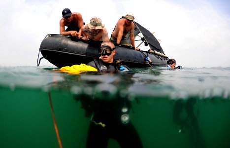 US Navy 100530-N-0413B-027 Navy Diver 2nd Class Brody Dorton waits as his SCUBA tanks' manifold is checked by (MDSU) 1 members before a recovery search dive