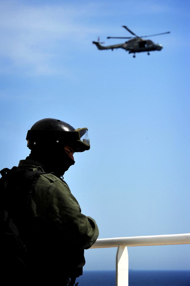 US Navy 100527-N-3136P-281 A Portuguese navy member of a visit, board, search and seizure team provides security while other members conduct an inspection aboard the Military Sealift Command container and roll-on-roll-off ship