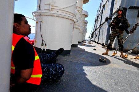 US Navy 100527-N-7364R-098 A Spanish navy visit, board, search and seizure team member stands guard over a detained crewmember aboard the Military Sealift Command container and roll-on-roll-off ship USNS LCPL Roy M. Wheat (T-AK