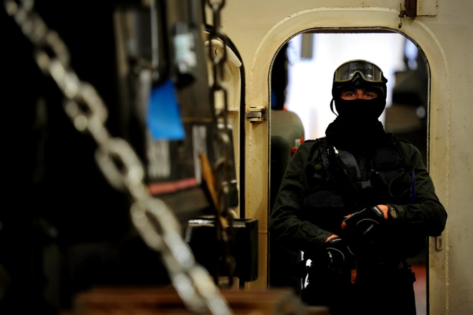 US Navy 100527-N-3136P-431 A Portuguese navy member of a visit, board, search and seizure team secures a cargo entrance while other members conduct the inspection aboard the Military Sealift Command container and roll-on-roll-o