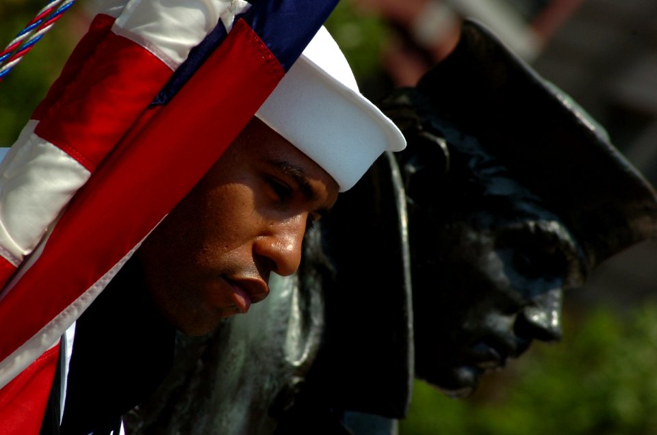 US Navy 100531-N-0506A-102 A sailor assigned to the U.S. Navy Ceremonial Guard holds the national ensign beside the Lone Sailor statue