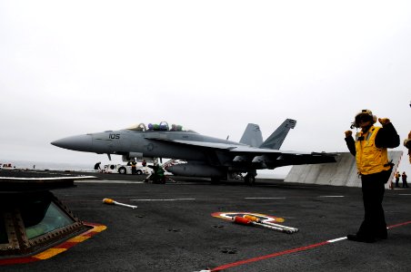 US Navy 100603-N-0232G-050 Aviation Boatswain's Mate (Handling) 1st Class Christina Duvall signals her fellow flight deck crew as an F-A-18 Super Hornet assigned to the Black Knights of Strike Fighter Squadron (VFA) 154 prepare