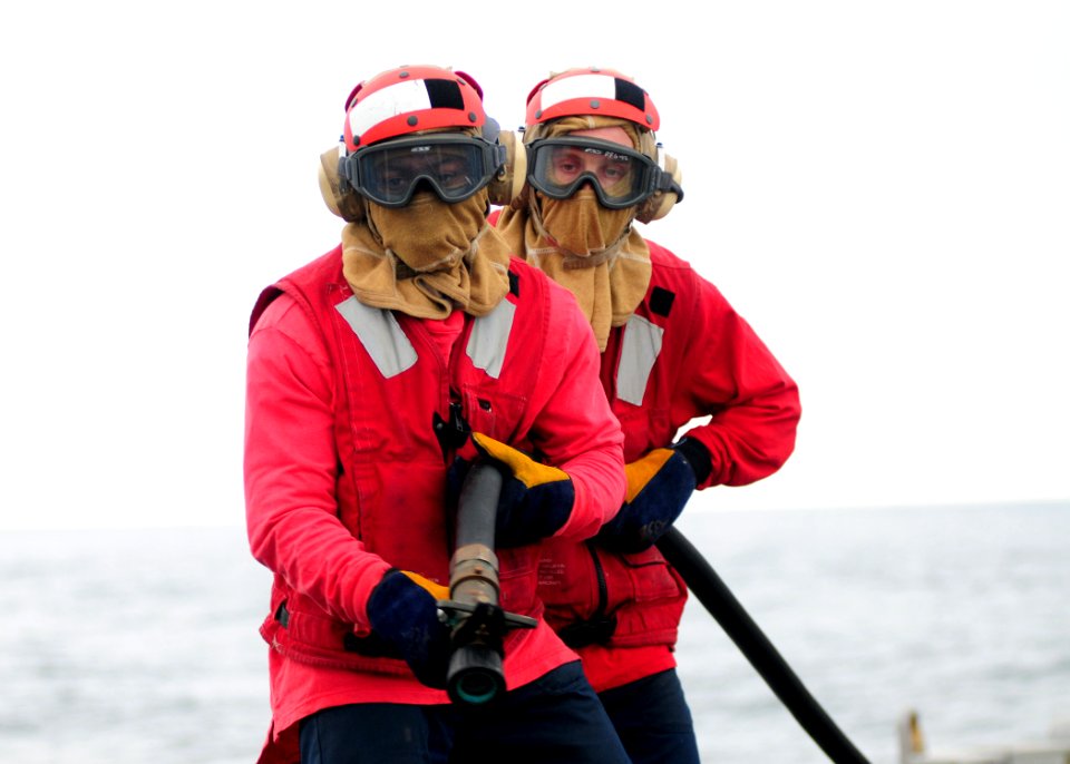 US Navy 100529-N-9301W-661 Damage Controlman Fireman Patrick Neal and Culinary Specialist 2nd Class Gary Snear stand a reflash watch during a helicopter crash drill aboard the guided-missile frigate USS Klakring (FFG 42)