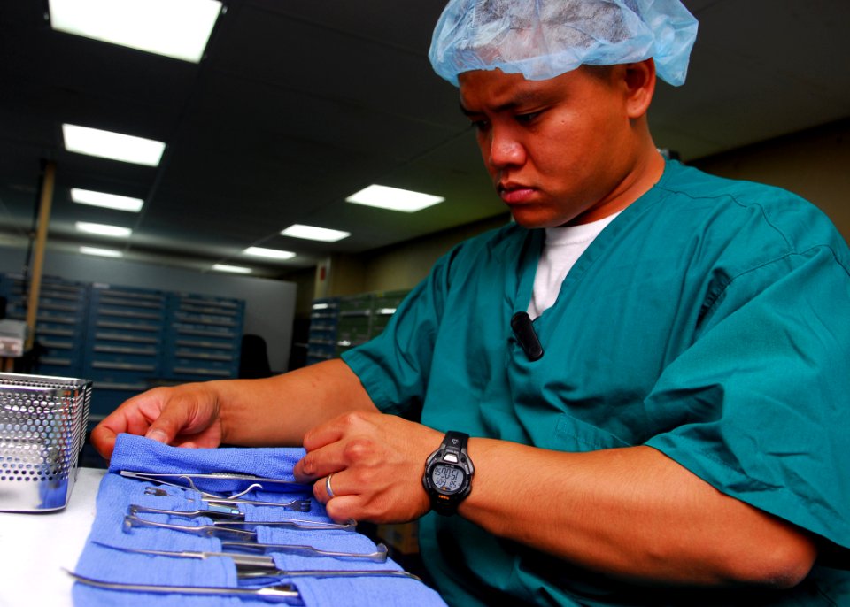 US Navy 100605-N-4044H-008 Hospital Corpsman 2nd Class Paul Cabalu arranges sterilized surgical tools in an autoclave to be cleaned