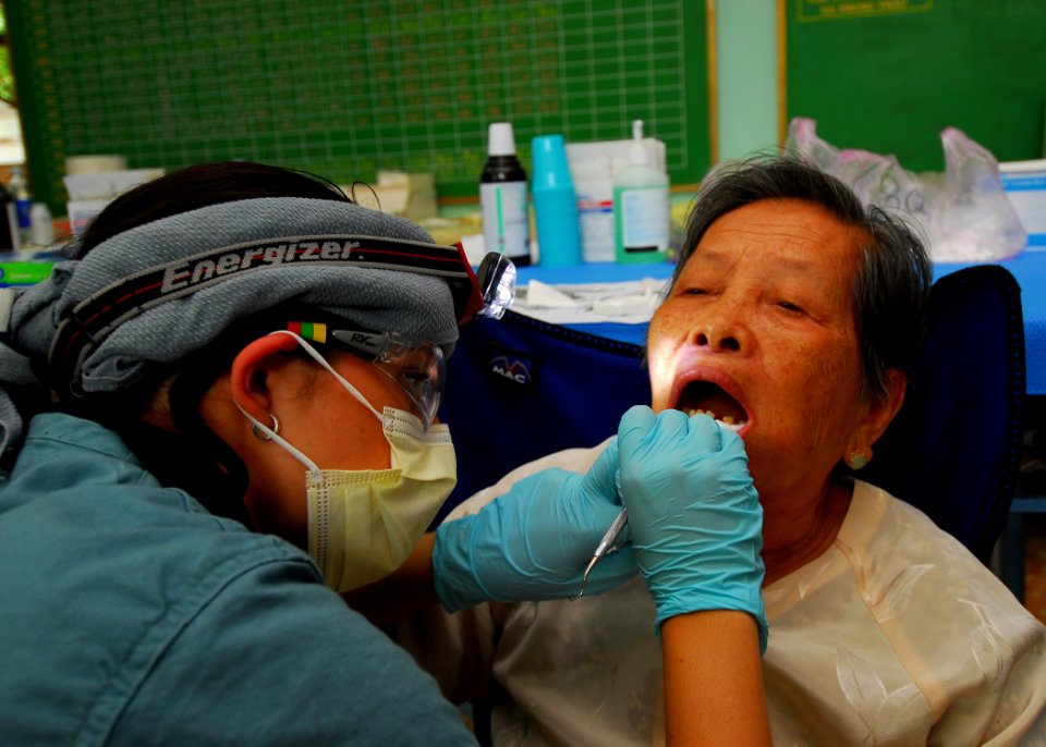 US Navy 100606-N-4044H-189 Lina Alsad examines the teeth of a Vietnamese patient during a Pacific Partnership 2010 dental civic action program