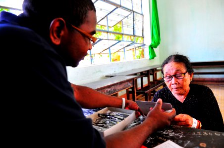 US Navy 100605-N-6597H-012 Hospital Corpsman 2nd Class Cahlil Weaver holds a mirror for a Vietnamese woman during an optometry evaluation during a Pacific Partnership 2010 medical civic action program