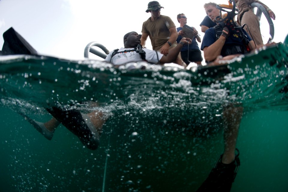 US Navy 100601-N-1134L-003 Sailors assigned to company 26 of Mobile Diving and Salvage Unit (MDSU) 2 and a Barbados Coast Guard diver prepare to conduct a salvage survey
