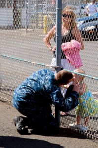 US Navy 100601-N-6674H-002 A Sailor kisses his daughter goodbye before leaving on western Pacific deployment