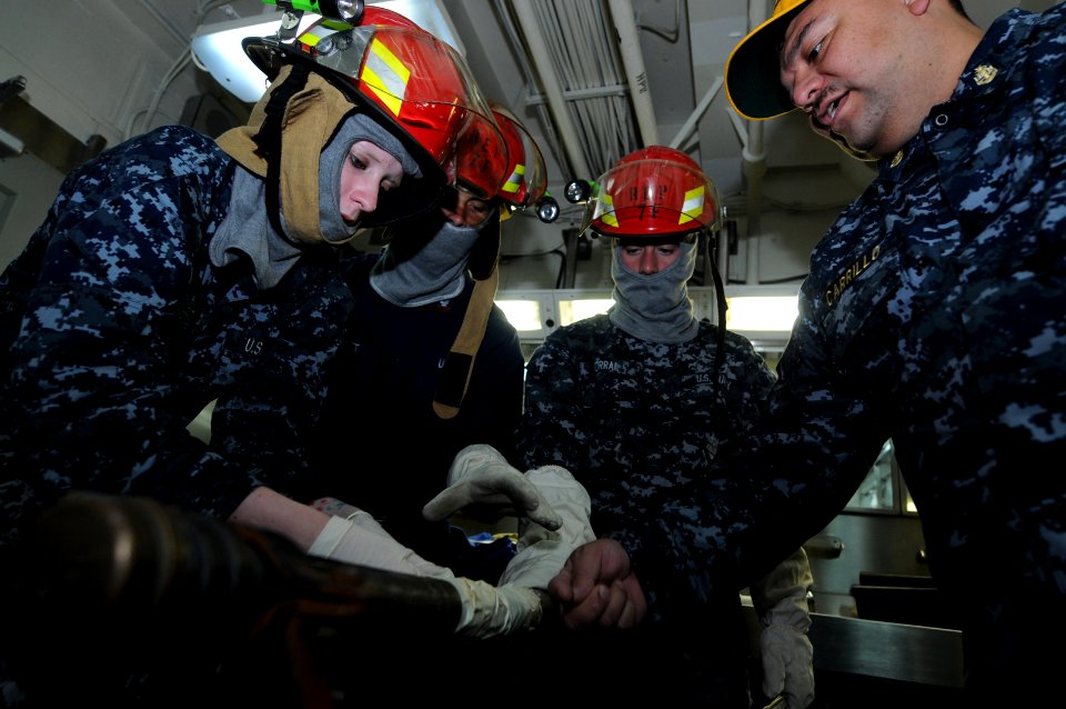 US Navy 100603-N-9132C-106 Ship's Serviceman Seaman Jessie Holbert, left, patches a pipe with an emergency water activated repair patch during a general quarters drill