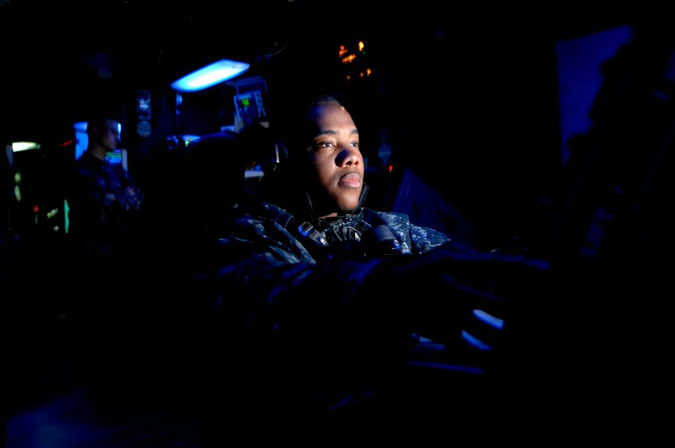US Navy 100602-N-6477M-172 Operations Specialist 2nd Class Cornelues Mitchell tracks surface contacts inside the Combat Information Center aboard the amphibious transport dock ship USS Cleveland (LPD 7)