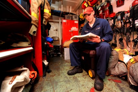 US Navy 100603-N-5082P-093 Damage Controlman Fireman Timothy J. Larsen studies professional military knowledge for his upcoming advancement exam in a repair locker aboard the aircraft carrier USS Enterprise (CVN 65)