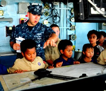 US Navy 100608-N-4378P-125 Mass Communication Specialist 1st Class Rafael Valdez explains how the ship is navigated from the bridge aboard USS Peleliu (LHA 5)