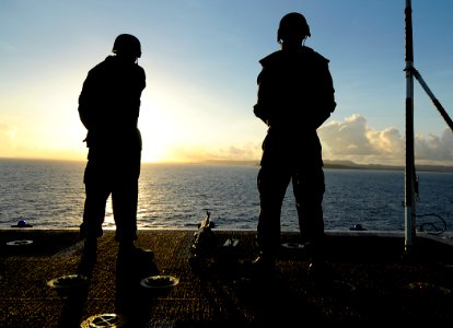 US Navy 100605-N-7948R-009 Sailors stand watch on the flight deck of the amphibious assault ship USS Peleliu (LHA 5) as it pulls into Guam for a scheduled port visit