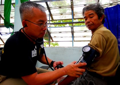 US Navy 100606-N-4044H-159 Lt. Cmdr. Hung Tran checks the blood pressure of a Vietnamese patient during a Pacific Partnership 2010 medical civic action program