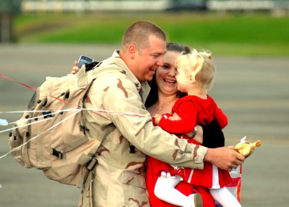 US Navy 100607-N-9520G-001 Yeoman 2nd Class Frank Morrel is greeted by his wife and daughter during a homecoming at Naval Air Station Whidbey Island photo