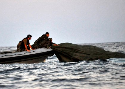 US Navy 100608-N-8689C-094 Navy SEALs and special warfare combatant-craft crewmen recover parachutes and personnel during a maritime craft aerial deployment system exercise near Fort Walton Beach photo
