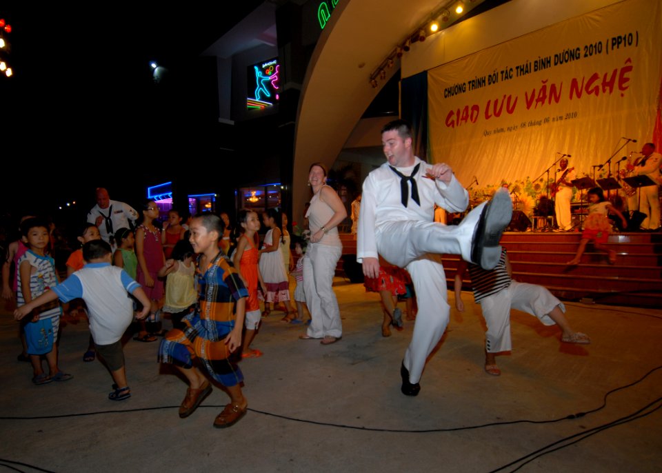US Navy 100608-N-0209M-015 Musician 3rd Class Gregory Legette dances with Vietnamese children at a U.S. Pacific Fleet Band concert at the Nha Van Hoa Lao Dong cultural center in Quy Nhon, Vietnam