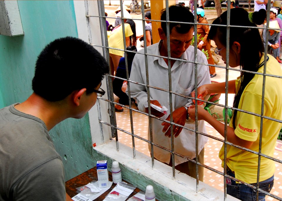 US Navy 100606-N-4044H-175 A Vietnamese translator removes the bracelet from a Vietnamese patient after receiving medications during a Pacific Partnership 2010 medical civic action program