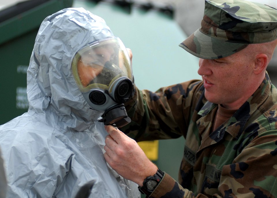 US Navy 100608-N-9520G-007 Master-at-Arms Seaman Peter Biloschaetzke, right, from Rancho Culamonga, Calif., checks the face mask seal on Master-at-Arms 2nd Class Lindsey Podd, from Allendale, N.J