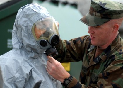 US Navy 100608-N-9520G-007 Master-at-Arms Seaman Peter Biloschaetzke, right, from Rancho Culamonga, Calif., checks the face mask seal on Master-at-Arms 2nd Class Lindsey Podd, from Allendale, N.J