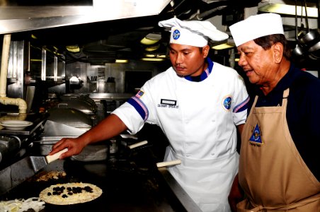 US Navy 100609-N-7939W-003 Seaman Justin Untalan learns how to make a quesadilla