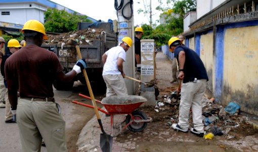 US Navy 100607-N-6410J-195 Sailors embarked aboard the Military Sealift Command hospital ship USNS Mercy (T-AH 19) load debris into a dump truck photo