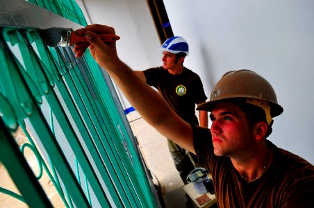 US Navy 100607-N-6597H-252 Sailors paint a gate during a Pacific Partnership 2010 engineering civic action program at the Hope Center school