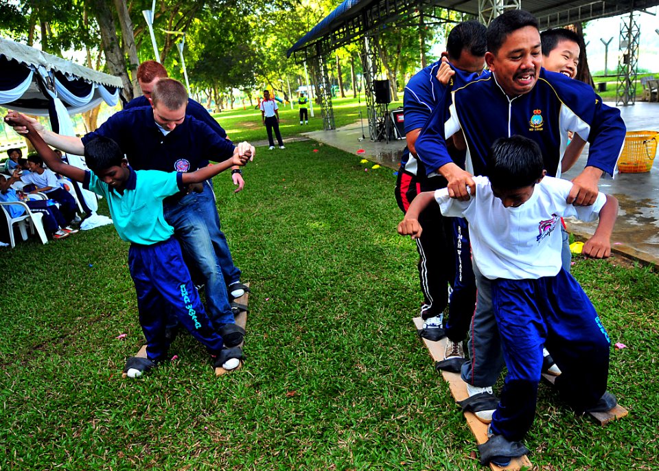 US Navy 100609-N-7643B-221 U.S. and Royal Malaysian Navy sailors and children from the Rumah Wawasan Children's Home participate in a team relay race