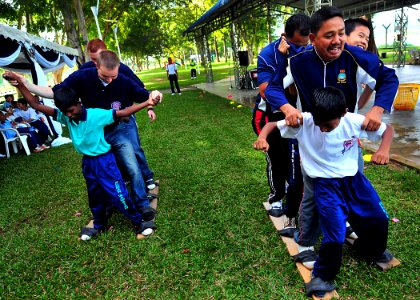 US Navy 100609-N-7643B-221 U.S. and Royal Malaysian Navy sailors and children from the Rumah Wawasan Children's Home participate in a team relay race