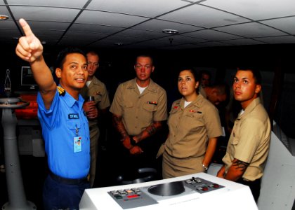 US Navy 100609-N-0995C-002 Royal Malaysian Navy Sub Lt. Syamsul Hari points out equipment on a bridge simulator to Sailors assigned to the guided-missile frigate USS Vandegrift (FFG 48)