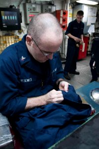 US Navy 100610-N-2735T-077 Damage Controlman 2nd Class Kurt Weisemes sews on his 2nd Class patches in preparation for being frocked aboard USS Nassau (LHA 4)