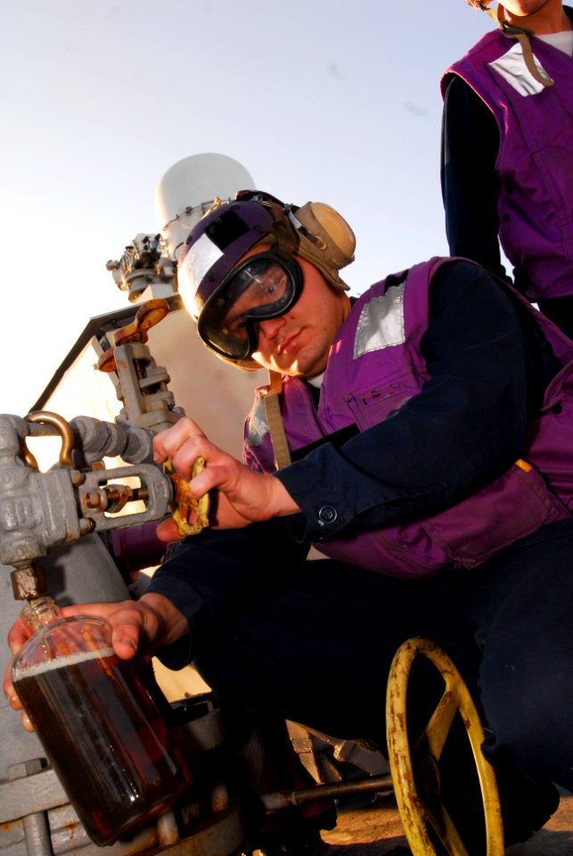 US Navy 100609-N-7638K-095 Gas Turbine System Mechanic 3rd Class Christopher Royoko takes a sample of marine diesel fuel for testing aboard the guided-missile frigate USS Taylor (FFG 50)