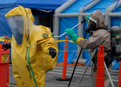 US Navy 100609-N-9520G-003 Lt. Craig Anderson, from Coupeville, Wash., assigned to the Oak Harbor Fire Department, decontaminates an entry team member during a mock chemical warfare agents training exercise