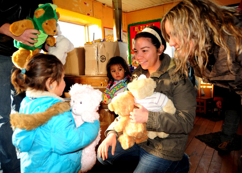 US Navy 100608-N-9301W-102 Lt. j.g Amelia Abbett, assigned to the guided-missile frigate USS Klakring (FFG 42), hands a bear to a preschooler during a community service project in Puerto Montt, Chile