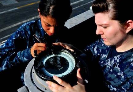 US Navy 100612-N-3595W-001 Quartermaster Seaman Gretel Ringstrom and Quartermaster Seaman Recruit Enze Pope use an azimuth circle to locate the position of the sun aboard the Nimitz-class aircraft carrier USS Dwight D. Eisenhow