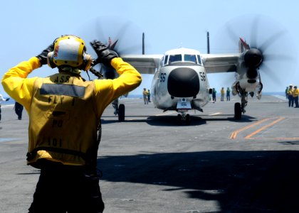 US Navy 100612-N-7908T-078 A Sailor signals to the pilot of a C-2A Greyhound aboard USS George H.W. Bush (CVN 77)