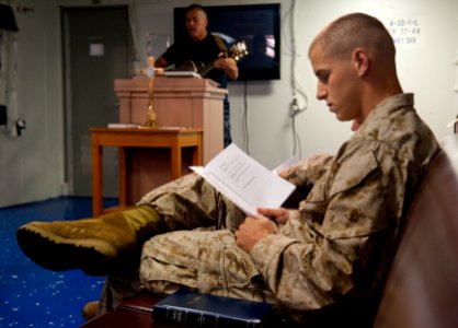 US Navy 100613-N-5319A-004 Chaplain Lt. David Cullen plays guitar during Protestant services in the chapel aboard the amphibious transport dock ship USS New Orleans (LPD 18)