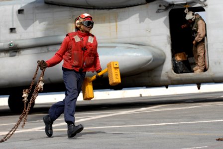 US Navy 100613-N-3358S-150 Aviation Boatswain's Mate (Handling) Airman Edward Toby, from Jacksonville, Fla., runs out to chock and chain a CH-53E Super Stallion helicopter