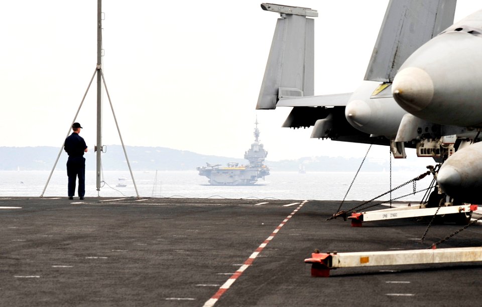 US Navy 100613-N-7317W-002 A Sailor looks toward the French navy aircraft carrier Charles De Gaulle (R 91) from the Nimitz-class aircraft carrier USS Harry S. Truman (CVN 75)