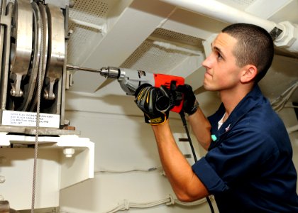 US Navy 100612-N-7908T-019 Aviation Ordnanceman 3rd Class Robert H. Little calibrates the overspeed governor in the ship's lower stage one machinery room aboard USS George H.W. Bush (CVN 77)