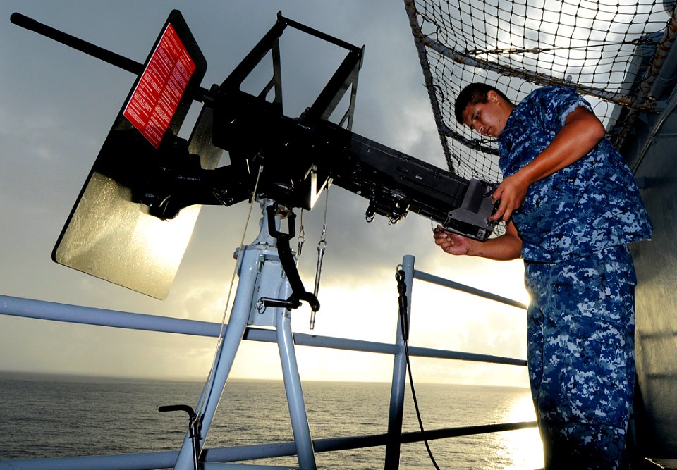 US Navy 100610-N-7948R-242 Aviation Ordnanceman 3rd Class John Dominguez reinstalls a 50-caliber machine gun to a mount aboard the amphibious assault ship USS Peleliu (LHA 5)