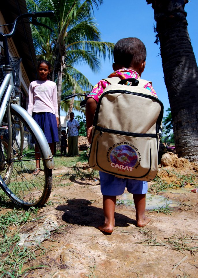 US Navy 100610-N-8539M-278 A Cambodian boy walks away with a backpack of hygiene items after visiting a U.S. Navy dentist during a Cooperation Afloat Readiness and Training (CARAT) Cambodia 2010